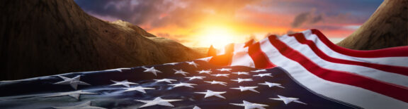 the American flag laying down waving towards sunshine