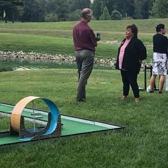 photo of people standing around a mini golf course setup