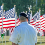 Field Of Memories Sponsorship Order Page Image - Photo of a Veretan standing facing a field of American Flags